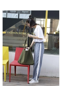Olive green canvas tote bag detail showing large capacity and durable fabric material