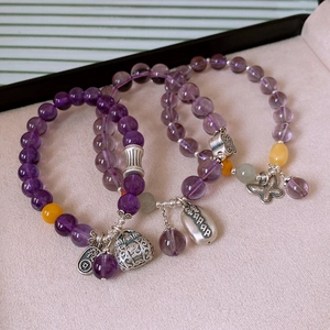 Detail of S925 silver amethyst bracelets with vintage lucky charms on velvet