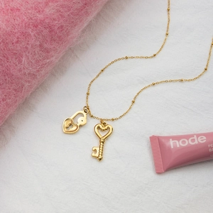Vue macro détaillée du pendentif serrure et clé en forme de cœur en or 18 carats sur chaîne
