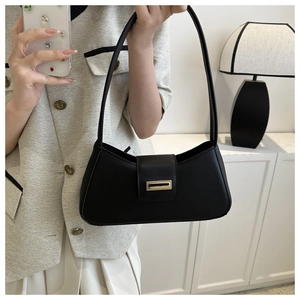 Detail view of the sleek black baguette bag featuring a premium gold rectangular buckle clasp