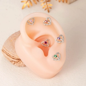Titanium steel heart-shaped stud earrings with colorful gemstones on a silicone ear model