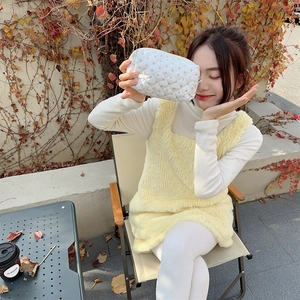 Quilted floral makeup bag held by model in a scenic outdoor camping setting