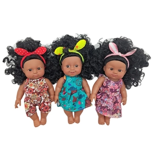 Three realistic black baby dolls in floral outfits with colorful headbands on white background