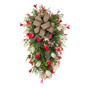 Detail of red and white floral Christmas wreath with burlap bow and LED lights