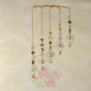 Detail of crystal suncatchers with gold moon and star metal accents and colorful beads