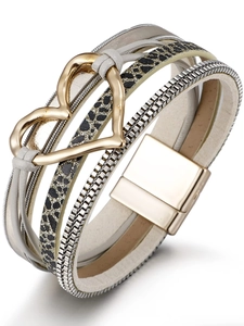 Dettaglio del bracciale multistrato con cuore dorato, stampa leopardata e chiusura magnetica