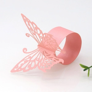 Detail of laser-cut pink butterfly paper napkin ring with pearl finish on white background