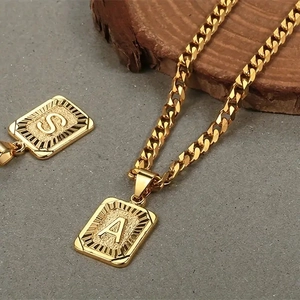 Dettaglio della catena cubana placcata oro 18k con ciondoli quadrati con lettere A e S