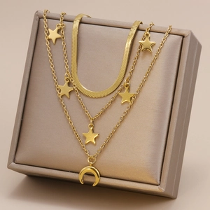 Collier doré multicouche avec pendentifs étoile et lune sur un présentoir à bijoux