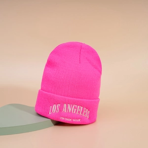 Détail de la broderie Los Angeles sur le bonnet en tricot rose vif avec texte