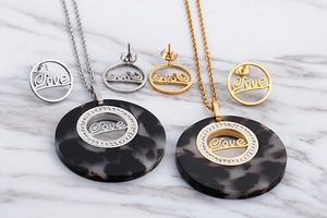 Detail view of retro gold and silver jewelry sets with marble resin and Love engraving