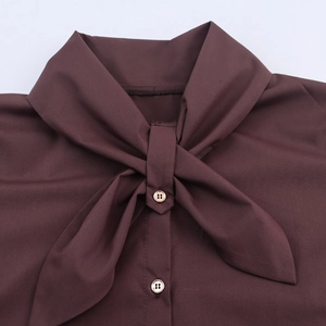 Deep brown long-sleeve blouse featuring a stylish neck tie and elegant gold buttons