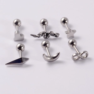 Macro detail of various stainless steel stud earrings including snake, heart, and moon shapes