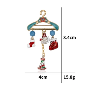 Detailed view of enamel Christmas hanger brooch with Merry Xmas socks and tree charms