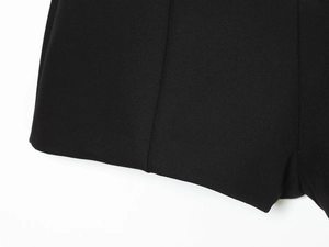Close-up of black woven fabric texture with precise vertical stitching and clean hem