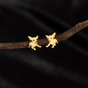 Boucles d'oreilles chien chihuahua dorées polies sur branche naturelle sur fond noir
