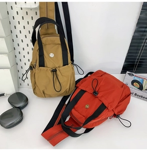 Detail showing two nylon crossbody bags in khaki and red colors with crinkled texture