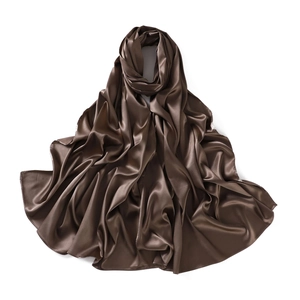 Detail showing the brown satin silk scarf texture with glossy drape on white background