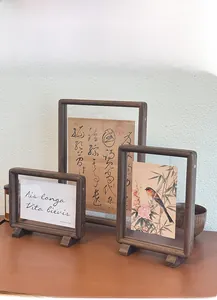 Detail view of double-sided walnut picture frames in three sizes with U-shaped bases