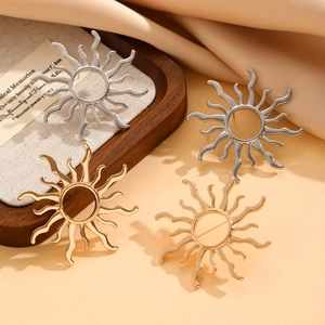 Detail of vintage sunburst stud earrings in gold and silver finish on display