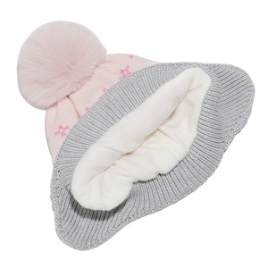 Detail of warm pink knit hat showing thick white fleece lining and soft faux fur pompom