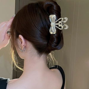 Vue détaillée d'une pince à cheveux argentée avec perle portée par un mannequin