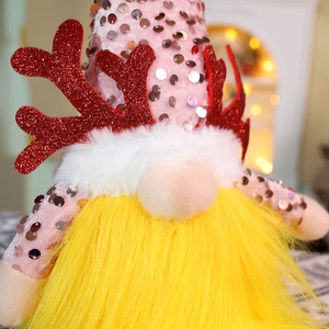 Close-up of a pink sequined Christmas gnome with glitter antlers and white plush details