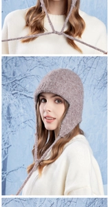 Detailed close-up of pink wool knit earflap hat with soft fuzzy texture and long ties