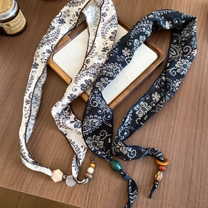 Detailed view of ethnic paisley scarves with vintage beads and wooden pendant charms