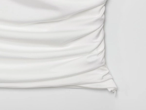 Detail of white pleated fabric showing the high-quality invisible side zipper