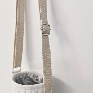 Close-up of adjustable woven shoulder strap and silver metal buckle on bear water bottle bag