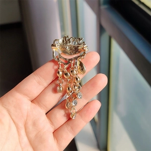 Detailed view of vintage gold tassel brooch with sparkling crystal pendants