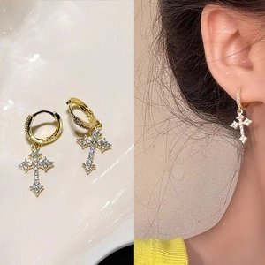 Gold cross hoop earrings with sparkling zircon crystals, shown in flat lay and on model