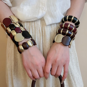 Detail view of chunky elastic bracelet with gold, burgundy and black resin link segments