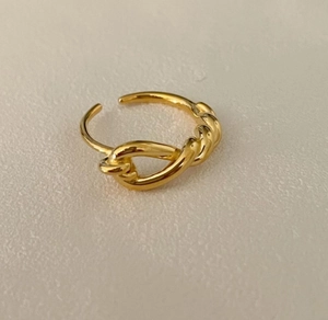 Detailed view of a gold-plated knot ring featuring a minimalist intertwined design