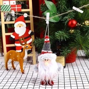 Detail view of Santa Claus knitted ornaments hanging in a cozy Christmas setting
