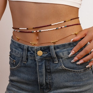Detail of 3-piece boho waist chain with glass beads and gold sequins on a female model