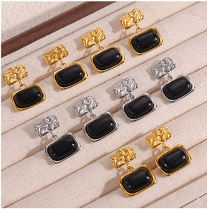 Macro shot of gold and silver plated earrings with vintage texture and black stones