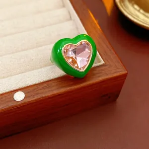 Minimalist green heart ring with large pink gemstone in a premium jewelry display box