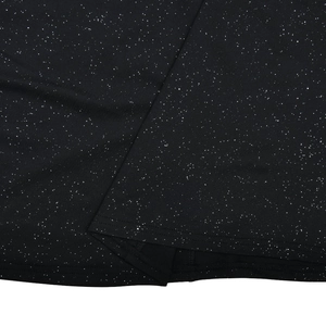 Gros plan sur le tissu pailleté noir montrant la texture et l'ourlet de la robe
