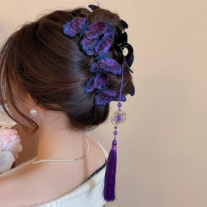 Dettaglio del fermaglio a farfalla ricamato viola con nappe e perle eleganti