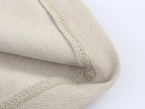Primo piano dettagliato che mostra le cuciture professionali e il tessuto in maglia beige