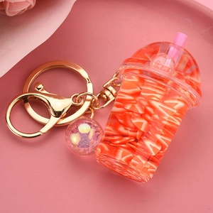 Detailed close-up of a pink milk tea cup keychain with liquid and orange slices inside
