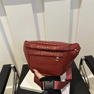Woven burgundy leather waist bag with gold zipper and adjustable crossbody strap