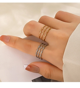 Detail of bamboo-style 18K gold and silver layered rings on a hand for stacking