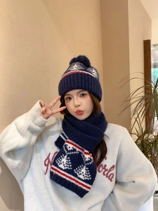 Dettaglio del set in maglia Fair Isle blu navy con cappello a pompon e sciarpa a motivi