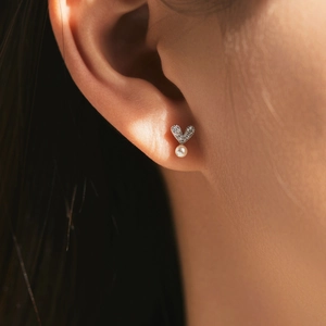 Exquisite 925 silver heart stud earrings with crystals and dangling pearls on a model