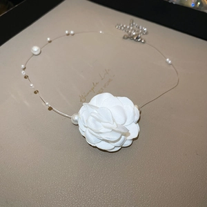 Vue détaillée du pendentif fleur de camélia blanc en tissu avec accents de perles