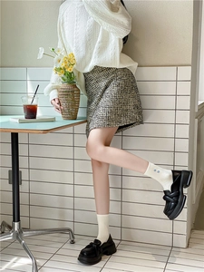 Detail of white cotton mid-calf socks with double heart embroidery and black loafers