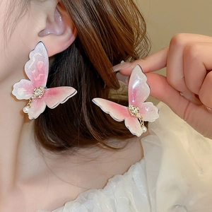 Pink butterfly earrings with rhinestones and pearls shown on a model
